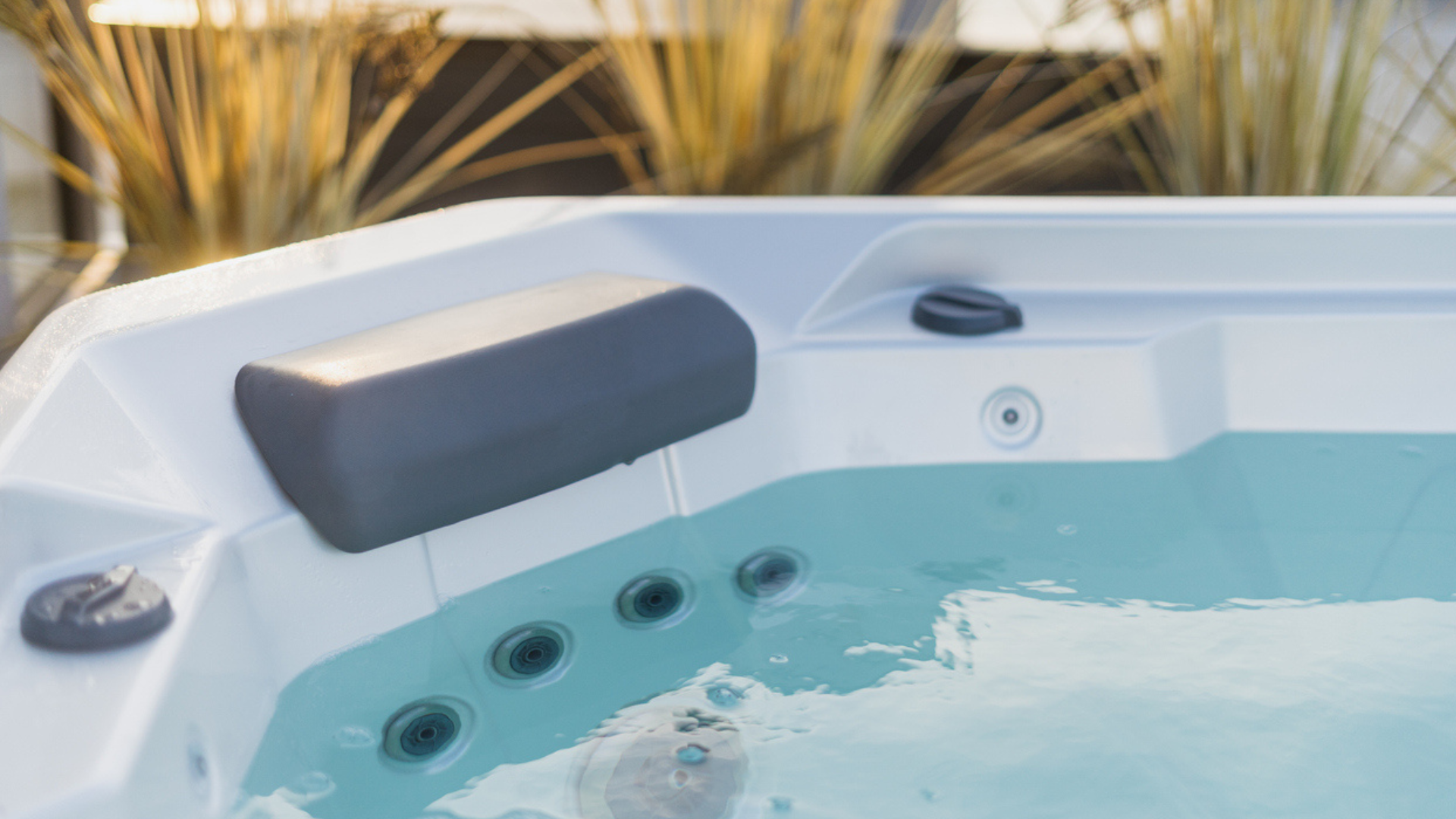 Hot tub on deck under blue sky near white vinyl fence. Cover is off after easy removal, showcasing hot tub cover options at Nejame & Sons in Danbury, CT & Carmel, NY.