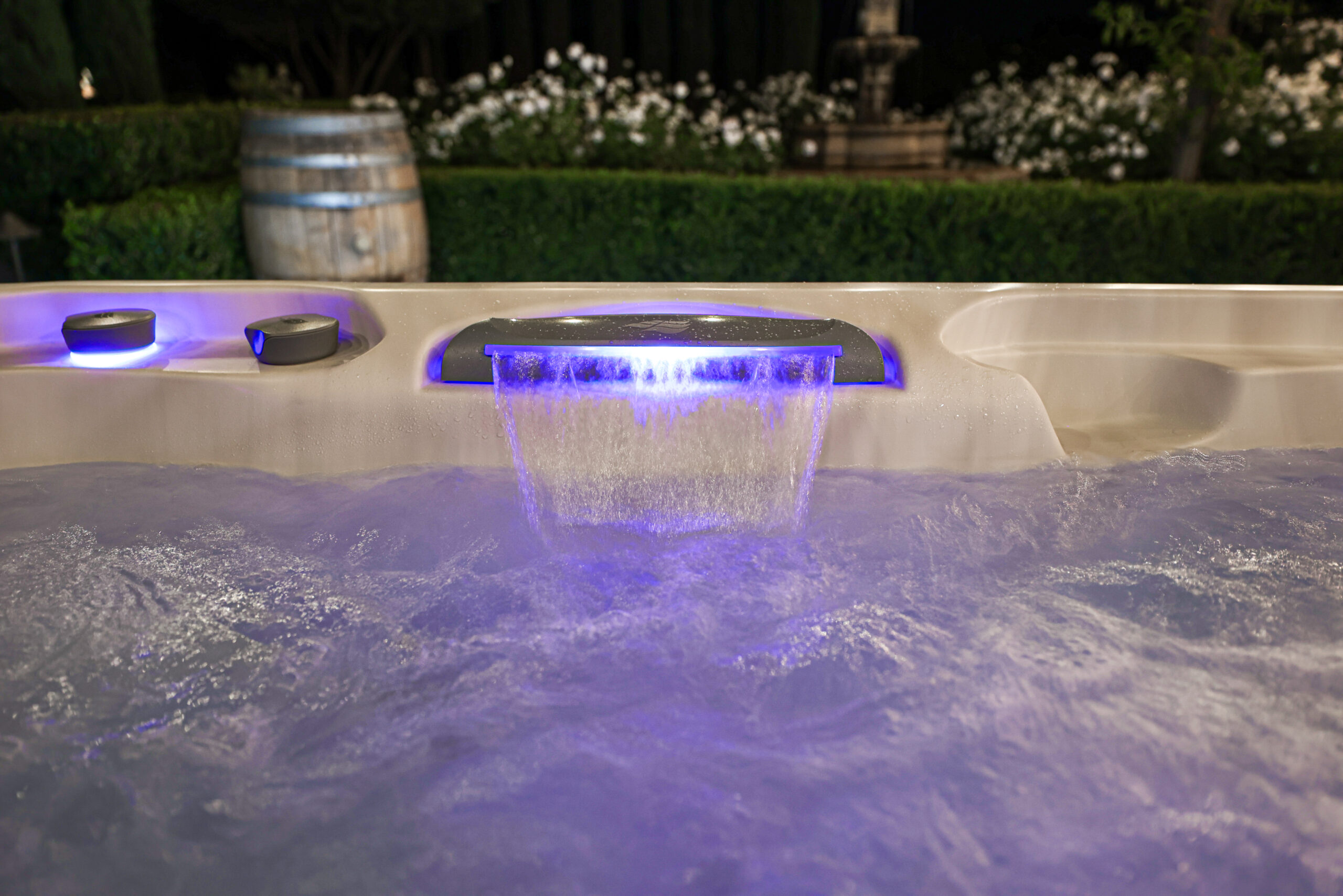 Up close of small waterfall feature of a hot tub at a Bethel, CT home. Waterfall back-illuminated by purple LED lights.